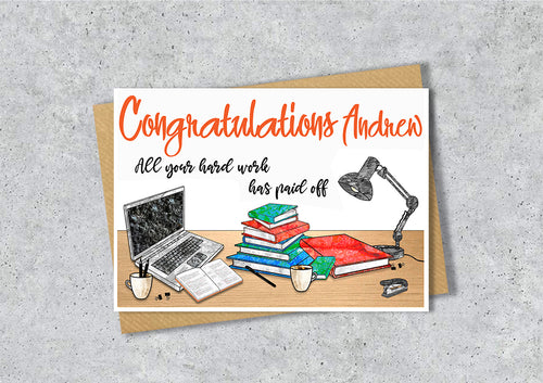 Greeting card with 'Congratulations Andrew' text and a illustration of a desk with books, laptop, and lamp.