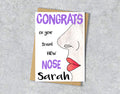 Congrats card with a female nose illustration saying "congrats on your brand new nose" with personalised text.