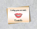 Greeting card with a smiley mouth illustration saying 'Loving your new smile' with personalised text.