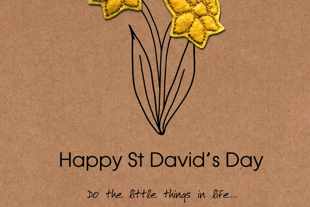 Two yellow flowers on a brown background with 'Happy St David's Day' text.